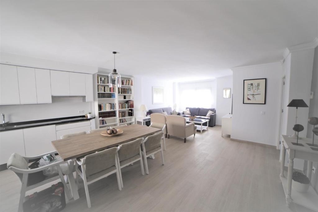 eine Küche und ein Wohnzimmer mit einem Tisch und Stühlen in der Unterkunft APARTAMENTO RIALTO 2 in Málaga