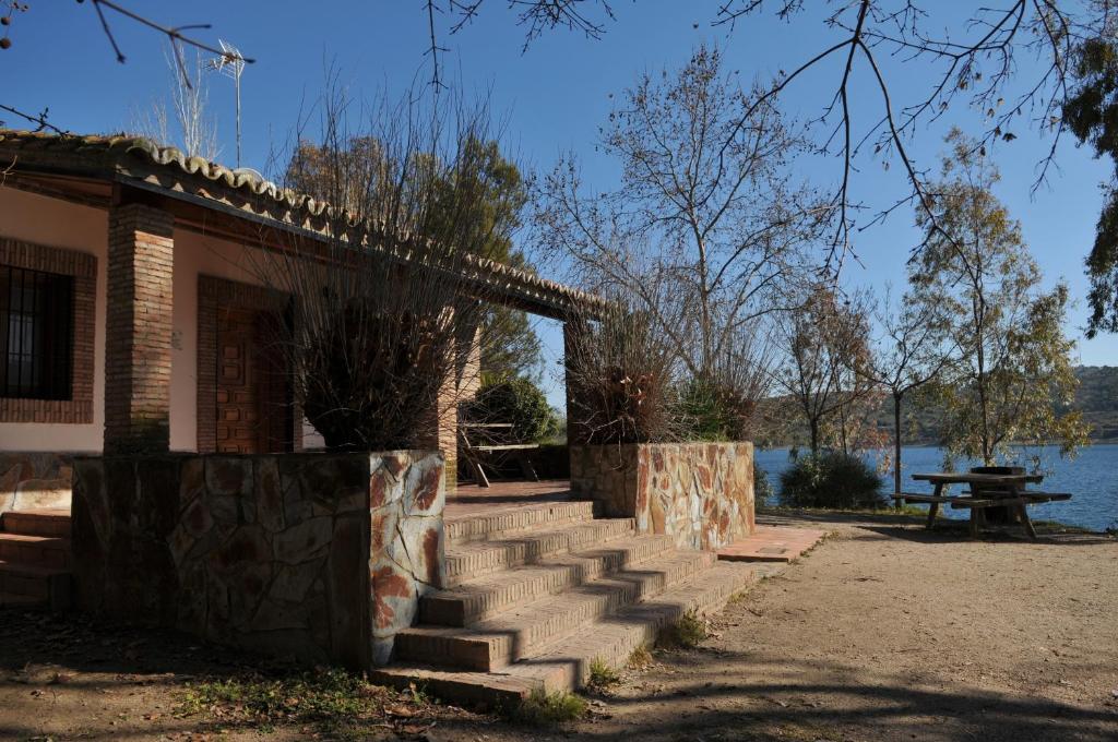 un bâtiment avec des escaliers à côté d'un lac dans l'établissement Casa Rural "Casa Isla del Zújar", à Castuera
