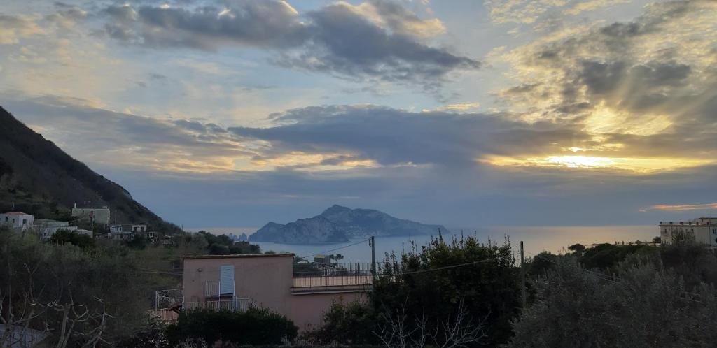 a sunset with a view of a mountain in the distance at Il Profumo di Capri in Massa Lubrense