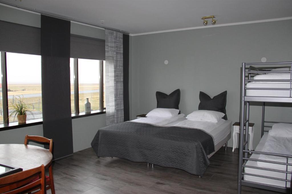 South Iceland Guesthouse في Steinar: غرفة نوم بسرير ونوافذ