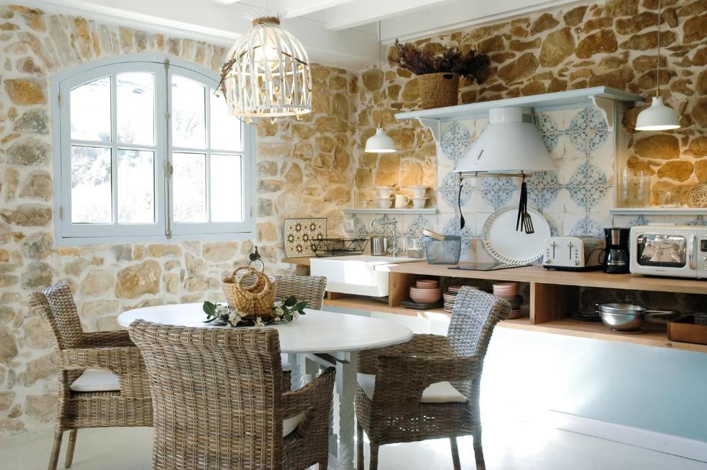 una cucina con tavolo, sedie e parete in pietra di Villa Inocencia a Santillana del Mar