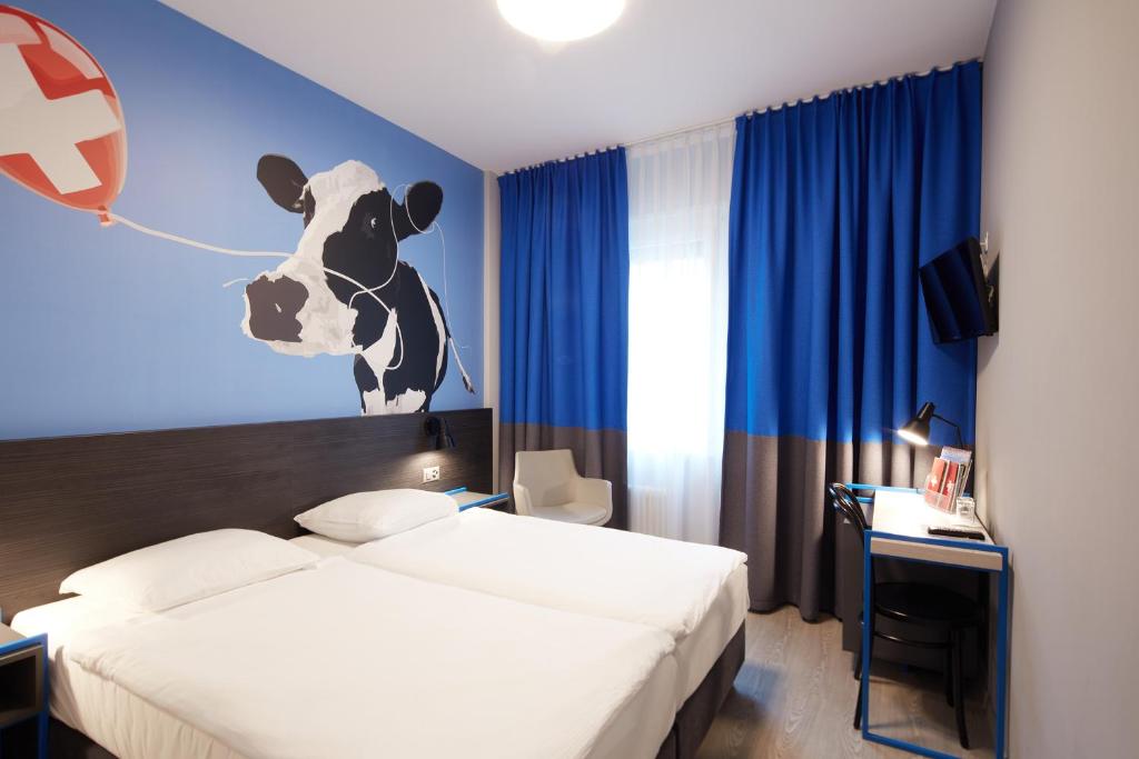 a bedroom with a bed with a cow head on the wall at Hôtel Crystal in Lausanne