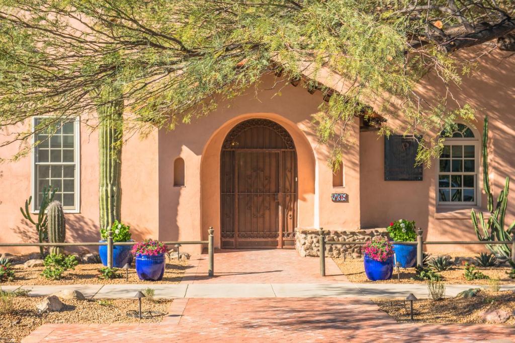 une maison avec des pots de fleurs bleus devant une porte dans l'établissement Armory Park Inn, à Tucson