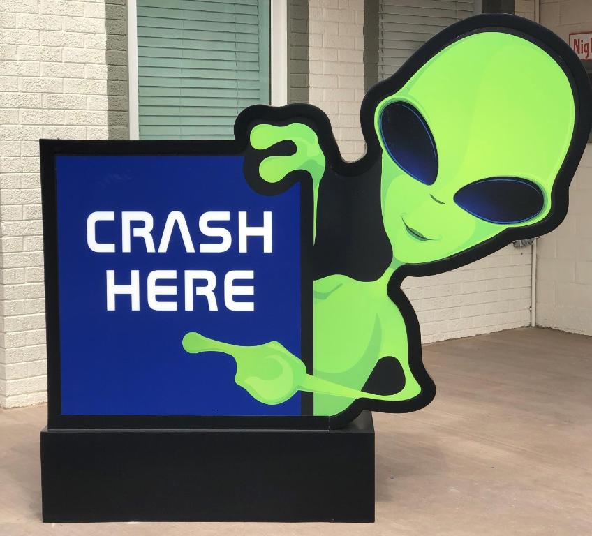 a sign that says crash here in front of a building at Roswell Inn in Roswell