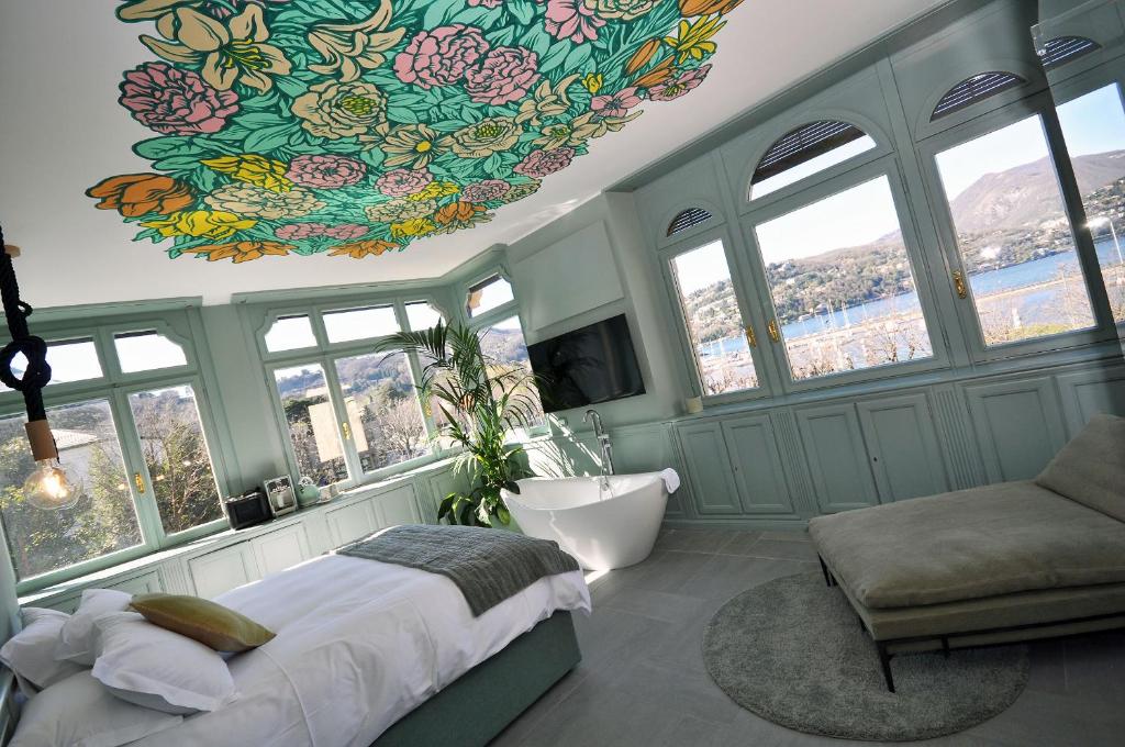 a bedroom with a large bed and a chandelier at Bello!Lake Como Suites in Como