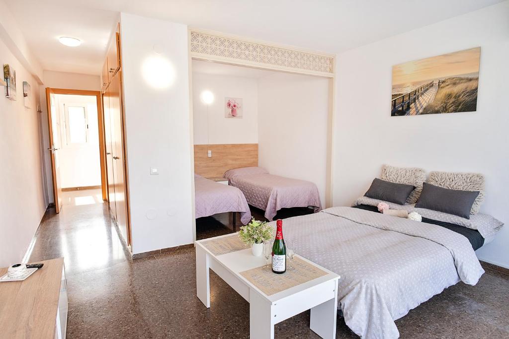 una habitación con una cama y un sofá y una mesa en Anne, en Salou