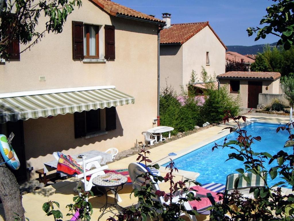 une villa avec une piscine en face d'une maison dans l'établissement Millau Aveyron Location Vacances, à Millau