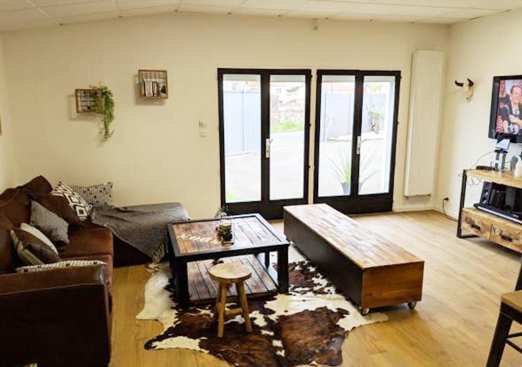 a living room with a couch and a table at Dépendance chaleureuse dans le vignoble nantais in La Haie-Fouassière