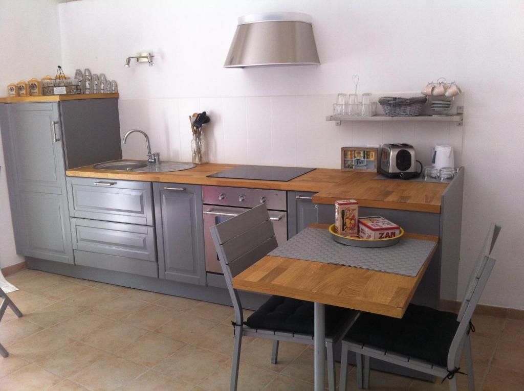 a kitchen with a table and a sink and a counter at Bastide Saint Jean Baptiste in Baudinard