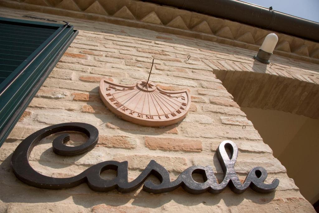 a sign on the side of a building with a clock at Casale del Conero in Porto Recanati