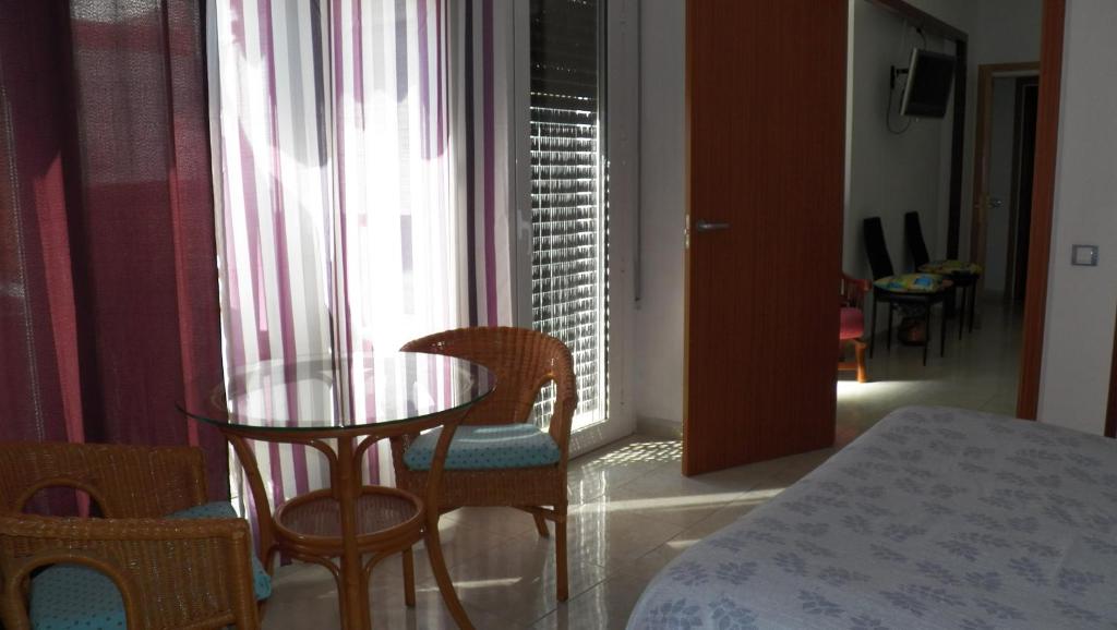 タレガにあるLa Casa del Centreのテーブルと椅子、窓が備わる客室です。