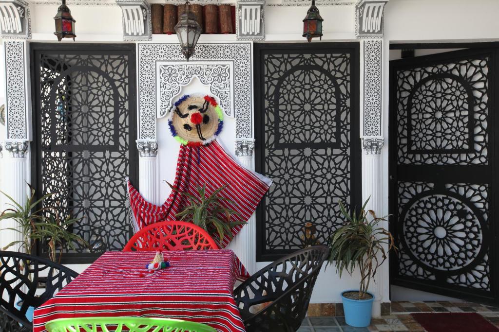 a red table and chairs on a patio at Dar Essaki 1886 in Tangier