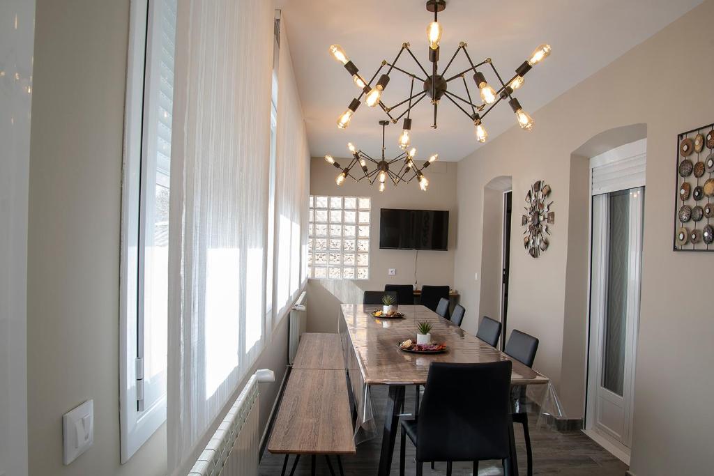 a dining room with a table and a chandelier at Alojamiento Turistico La Casa del tio Cesar in Cañas