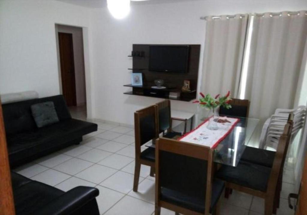 ein Wohnzimmer mit einem Tisch, Stühlen und einem Sofa in der Unterkunft Marina Clube in São Pedro da Aldeia