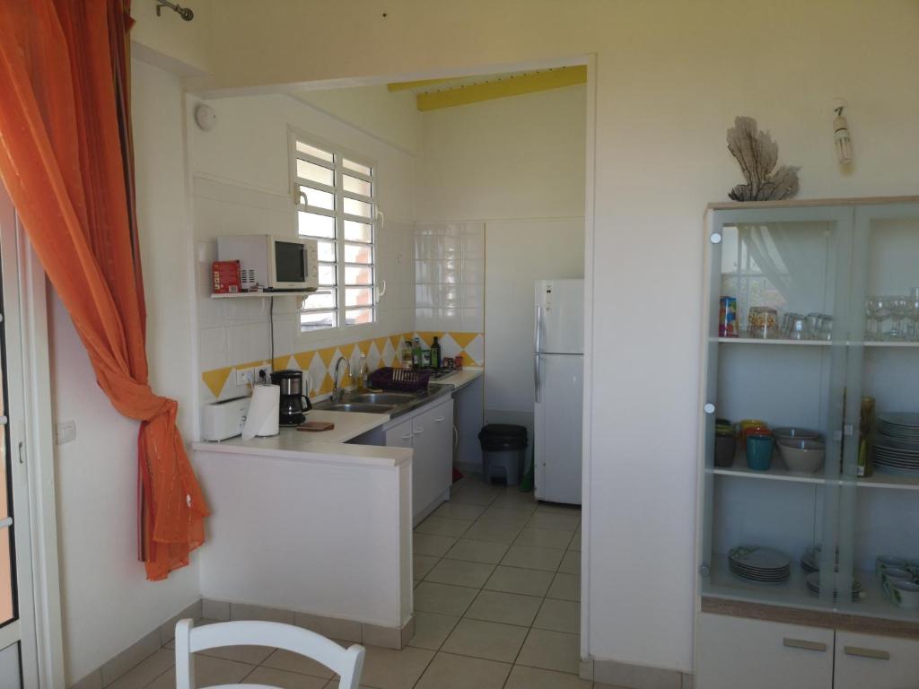 a white kitchen with a counter and a refrigerator at Beau F2 avec vue sur Les Saintes in Trois-Rivières