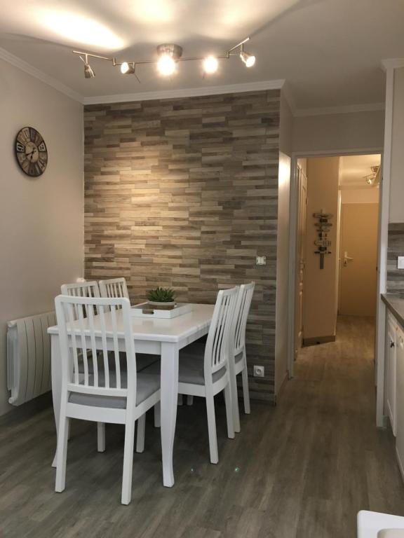 a dining room with a white table and chairs at Les Restanques du Golfe de saint Tropez in Grimaud