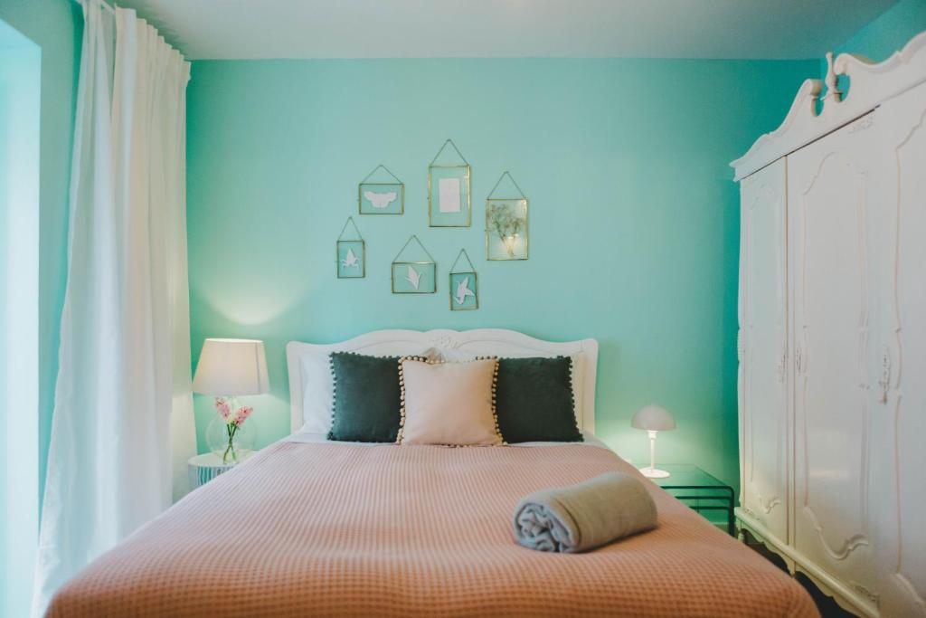 a bedroom with a large bed with blue walls at Jasmim in Setúbal