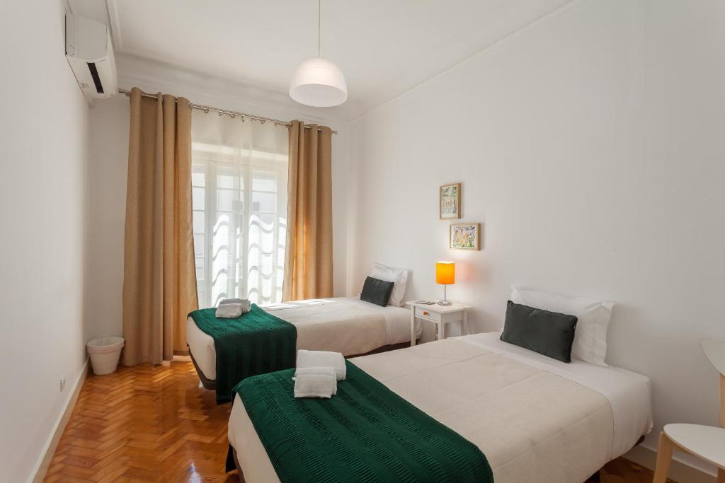 um quarto de hotel com duas camas e um sofá em MouraLua em Sintra