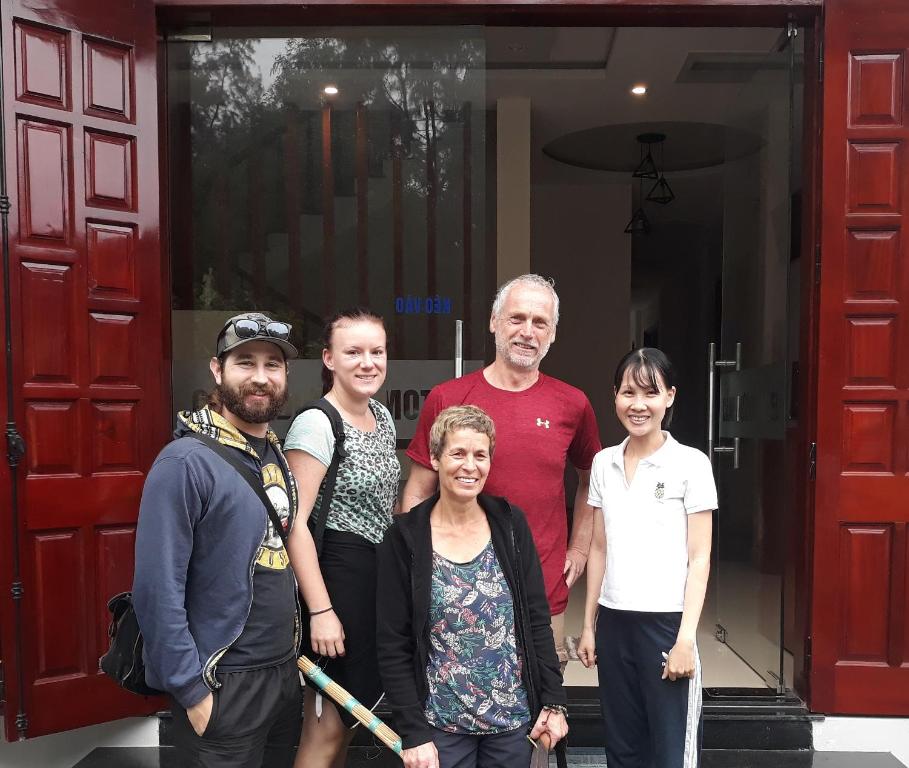 a group of people standing in front of a door at CANH DUONG MOTEL in Lang Co