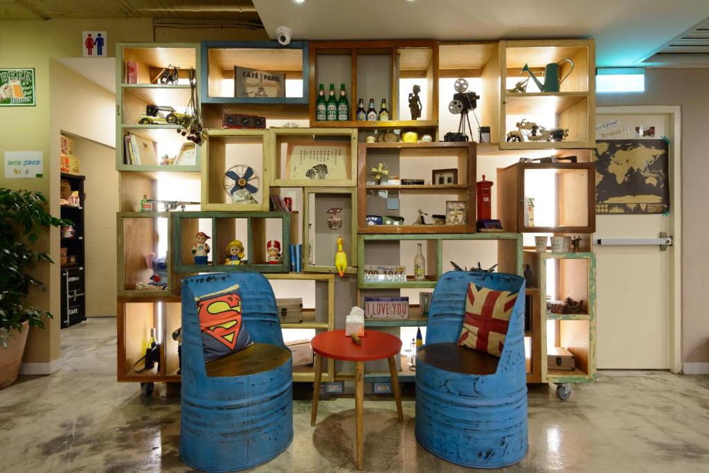 a room with two chairs and a table and shelves at Hualien Wow Hostel in Hualien City