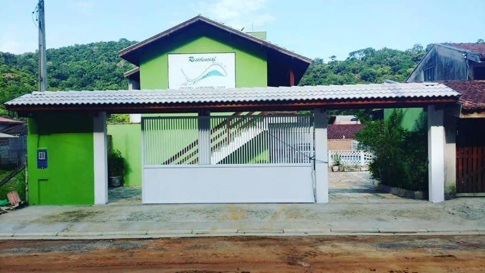 a green and white garage with a white gate at Montanhas Bem Te Vi in Caraguatatuba