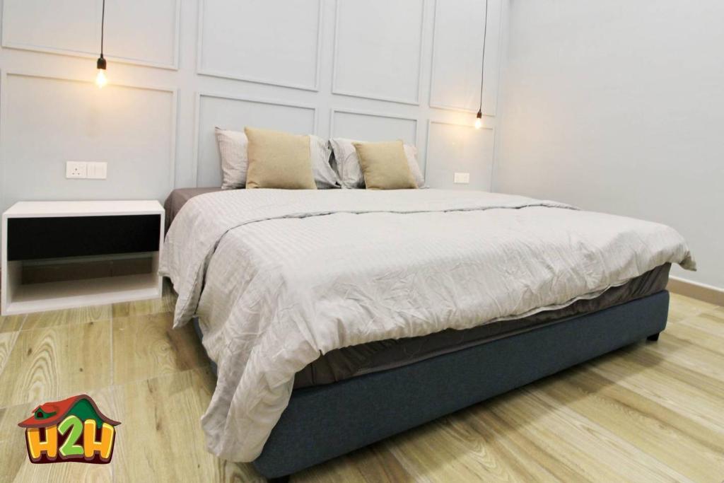 a bedroom with a large bed and a white wall at H2H - Sweet Cottage - Octagon in Ipoh