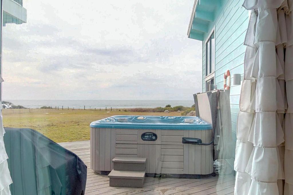 a hot tub on a deck with a view of the ocean at Stella Del Mare in Fort Bragg