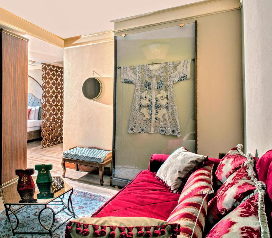 a living room with a red couch and a large mirror at Romance Istanbul Hotel Boutique Class in Istanbul