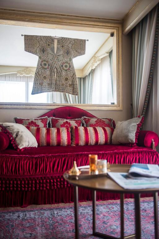 a red couch in a living room with a table at Romance Istanbul Hotel Boutique Class in Istanbul