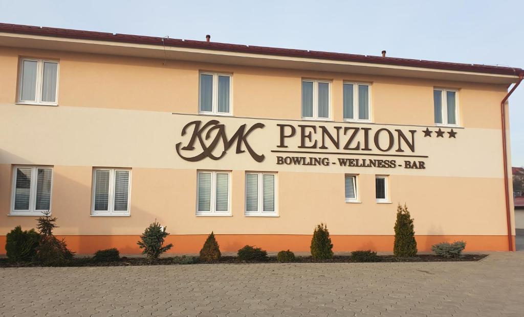 a building with writing on the side of it at KMK Penzión in Lednické Rovne