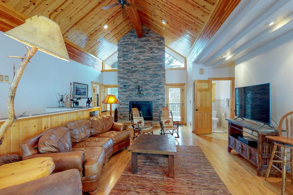 a living room with a couch and a fireplace at Antler Ridge in Big Sky