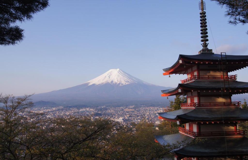 um pagode com uma montanha ao fundo em 富士山結アパートメント em Fujiyoshida