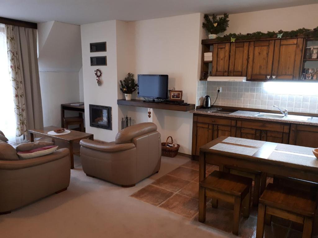 a kitchen and living room with couches and a table at Apartman Kuka Tatranská Lomnica in Tatranská Lomnica