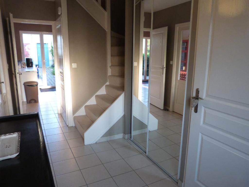 a hallway with a glass door and stairs at Chez Grace in Wissant