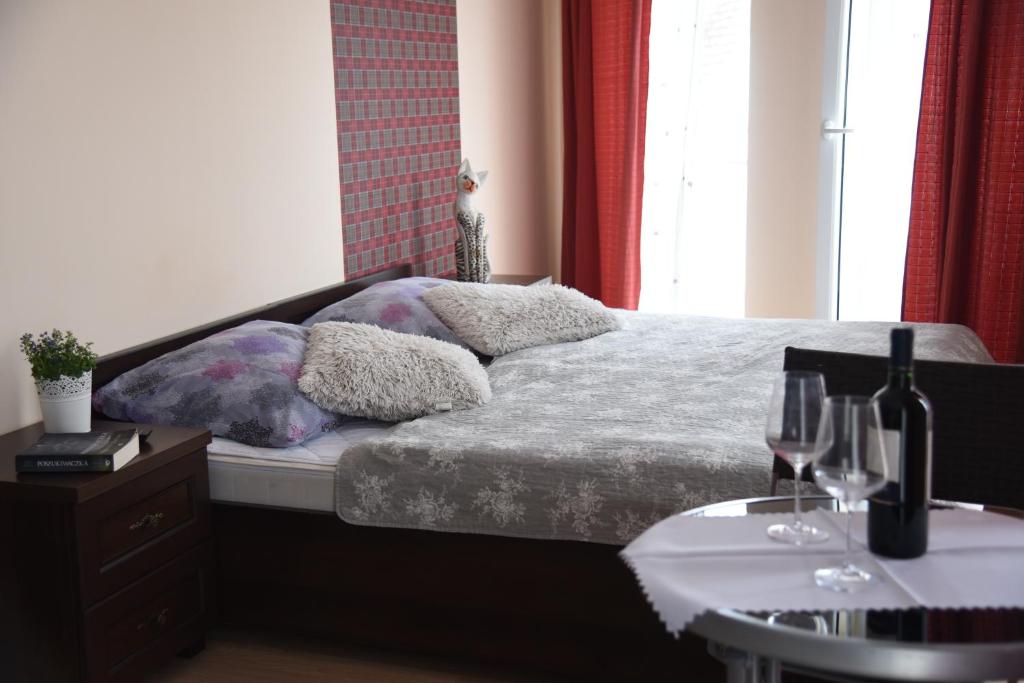 a bedroom with a bed and a table with wine glasses at Nestor Centrum in Mrzeżyno