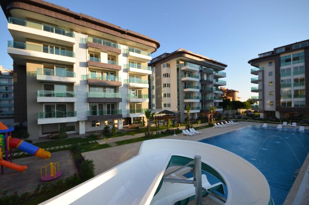 un complejo de apartamentos con piscina y parque infantil en Moda Marine Residence, en Alanya