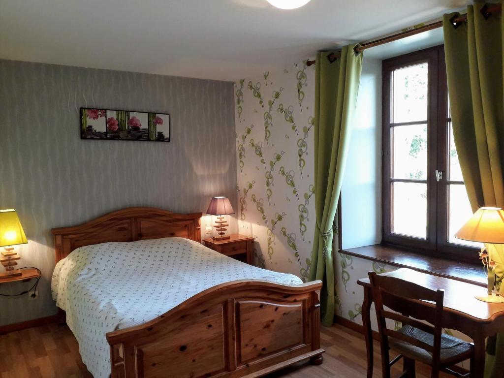ein Schlafzimmer mit einem Holzbett und einem Fenster in der Unterkunft la ferme des tertres in La Chapelle-près-Sées