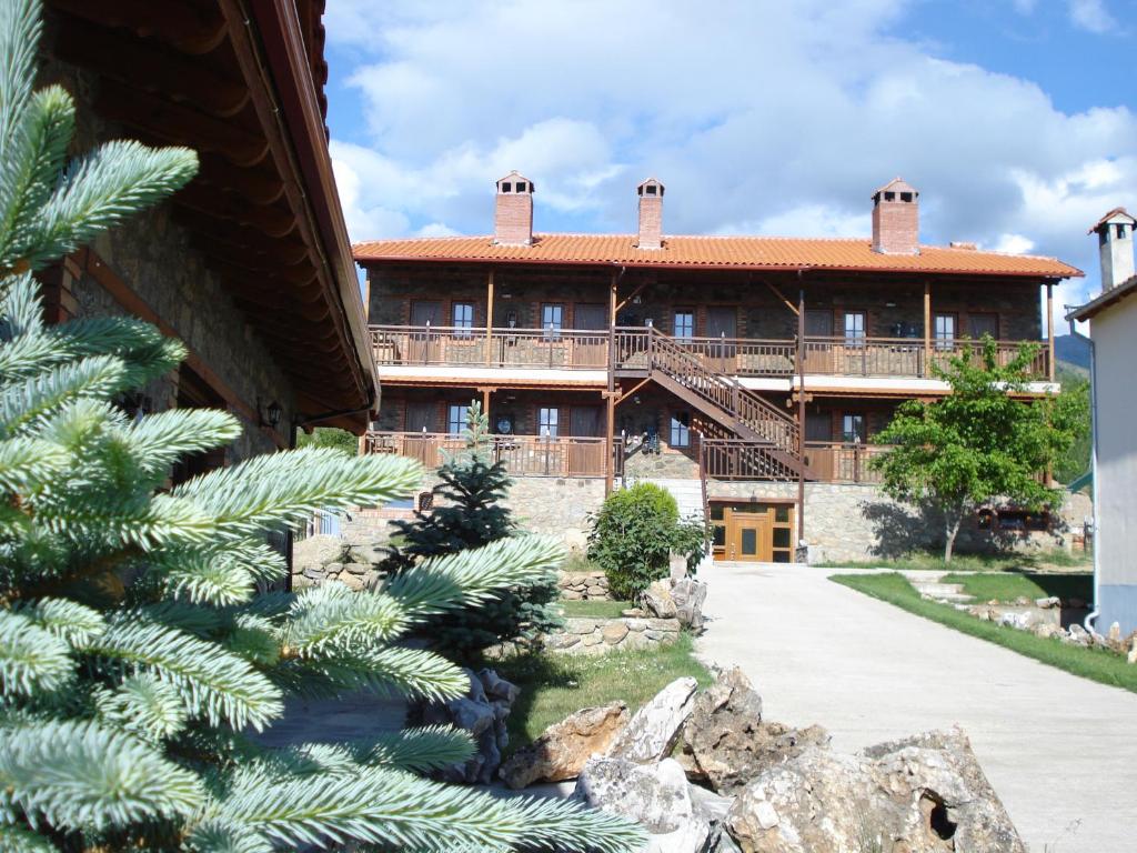 una vista exterior de una gran casa con un árbol en Prespa Resort & Spa, en Platy