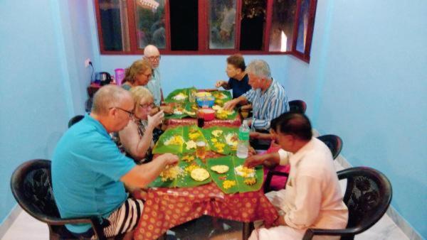 a group of people sitting around a table eating at Cherai Ocean View Home in Cherai Beach