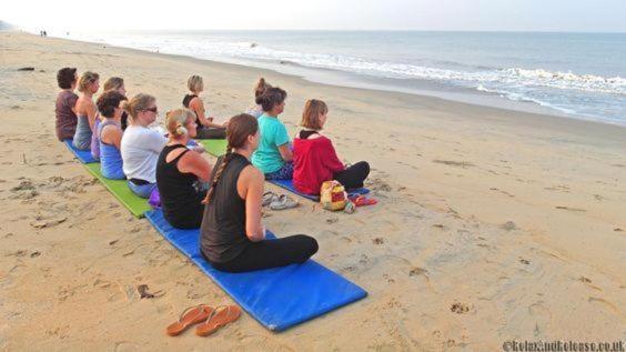 a group of people sitting on the beach at Cherai Ocean View Home in Cherai Beach