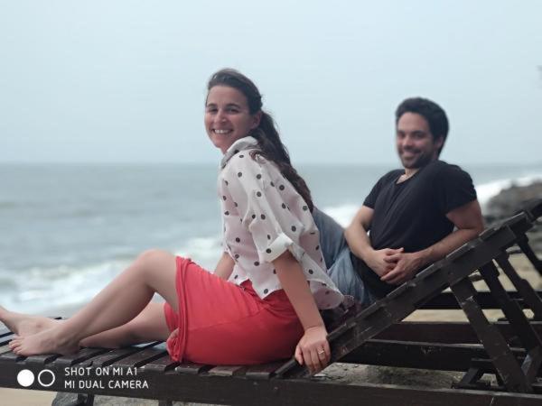 a man and a woman sitting on a bench at the beach at Cherai Ocean View Home in Cherai Beach