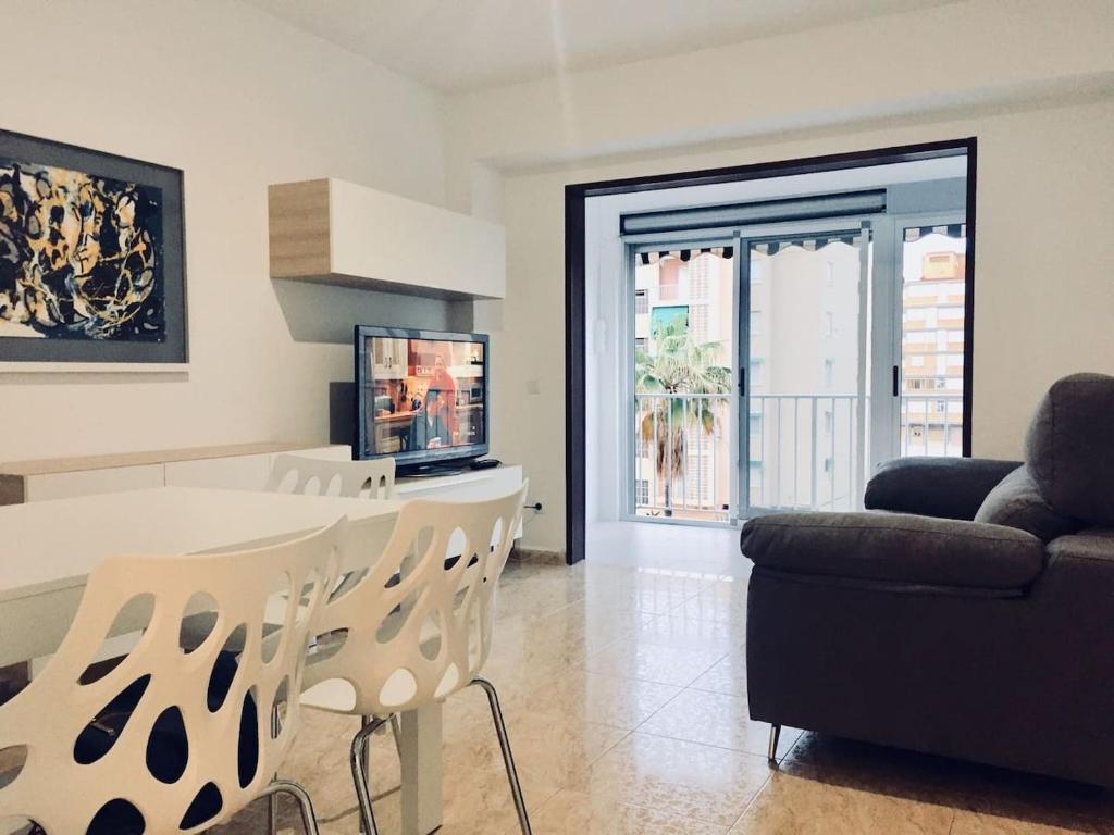 a living room with a table and a couch at Apartamento en playa Gandia con piscina y parking in Playa de Gandia
