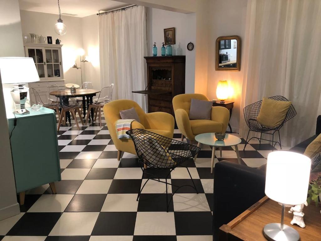 a living room with chairs and a checkered floor at 2 Rue de l'Église in Aizecourt-le-Haut