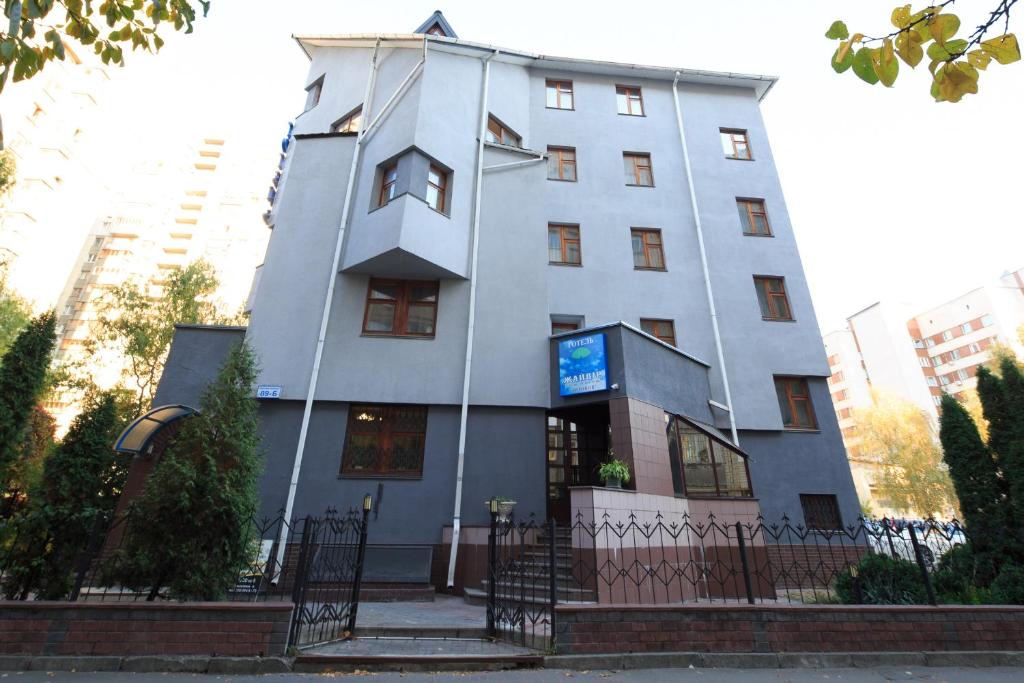 un edificio blanco alto con un letrero. en Zhayvir en Kiev