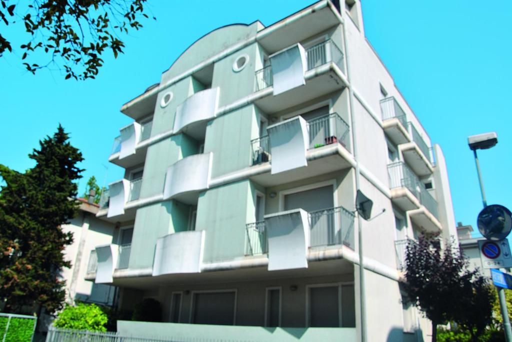 un alto edificio bianco con balconi di Residenza Manuela a Riccione