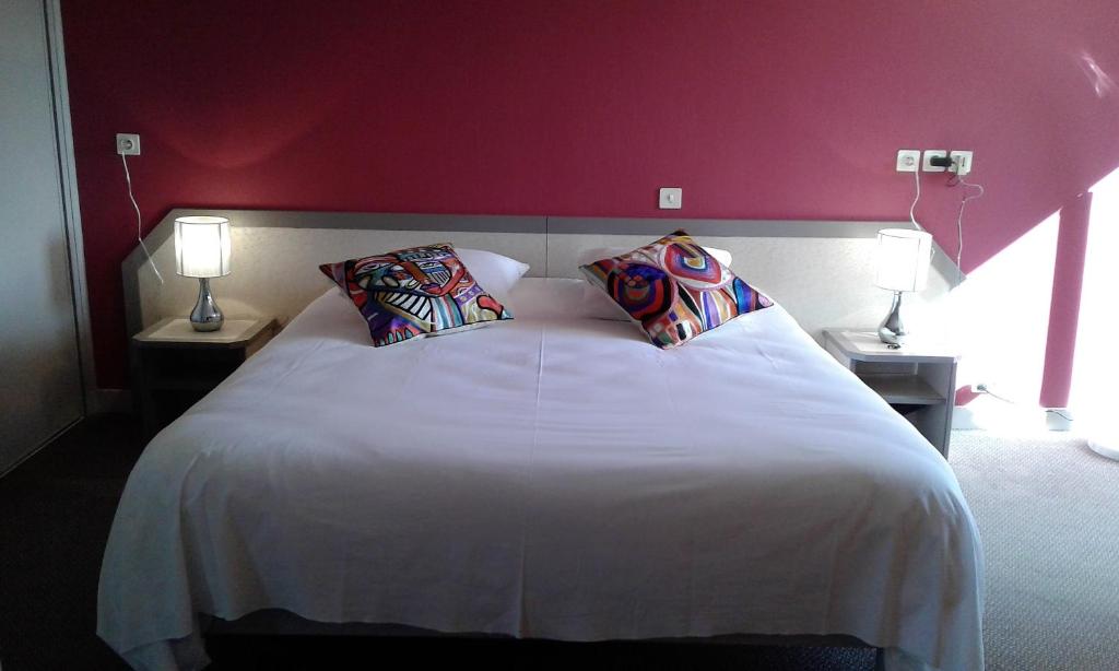 En eller flere senge i et værelse på Hotel Restaurant Le Capricorne