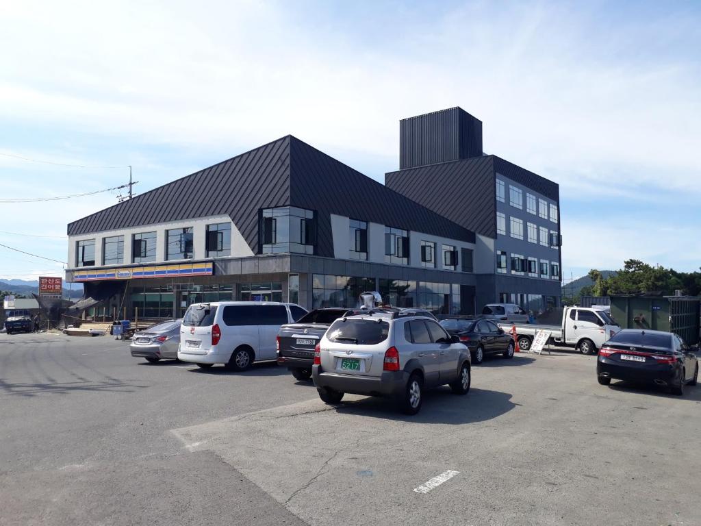 a parking lot with cars parked in front of a building at Tongyeong Bridge Hotel in Tongyeong