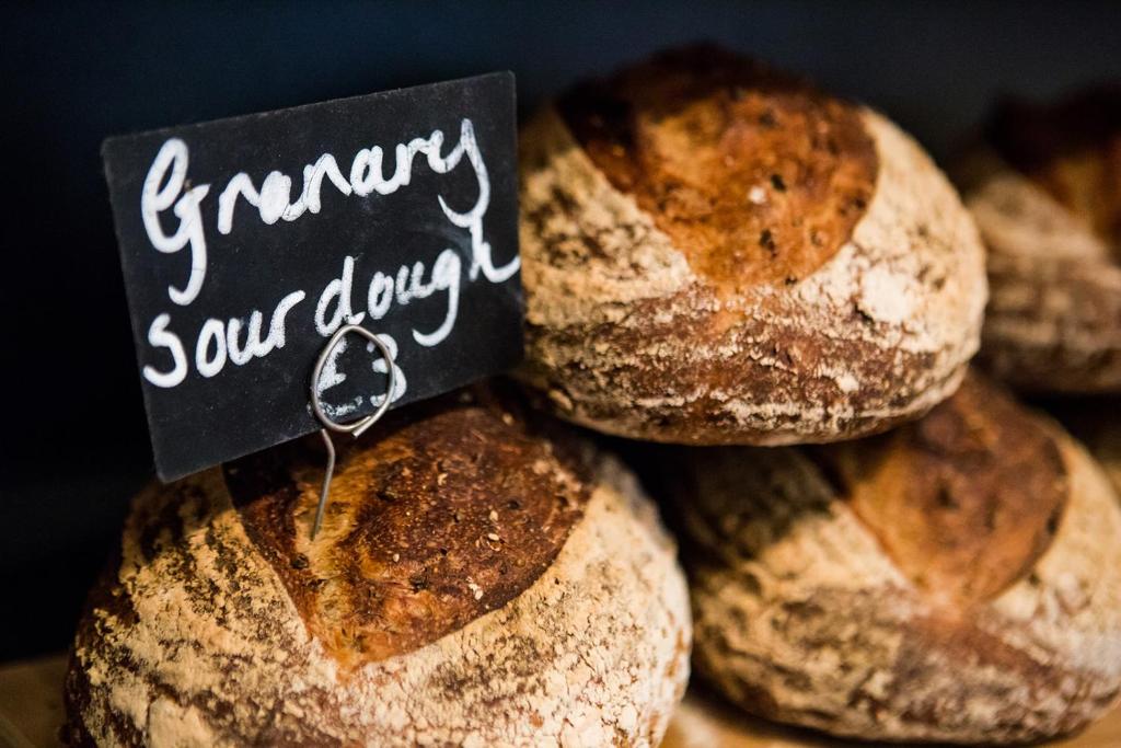 a pile of bread with a sign that reads granny sour dough at Whitehouse Rye in Rye