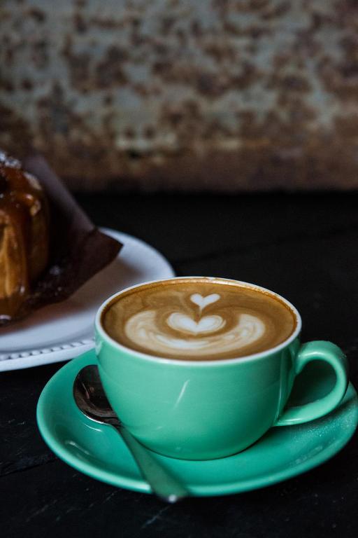 a green cup of coffee on a green plate with a pastry at Whitehouse Rye in Rye