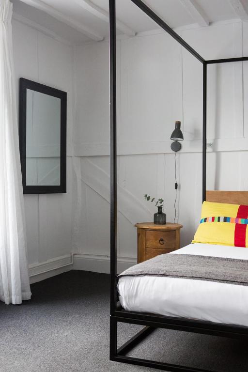 a bedroom with a canopy bed and a mirror at Whitehouse Rye in Rye